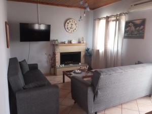 a living room with a couch and a chair and a tv at NTARAS HOME in Pinakokhórion