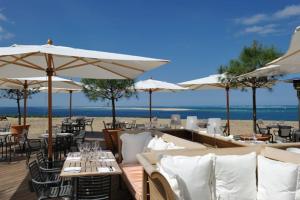 a restaurant on the beach with tables and umbrellas at La cabane du littoral in La Teste-de-Buch
