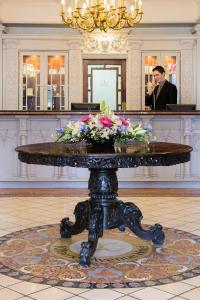 a man standing in a lobby with a table with flowers on it at Killarney Avenue in Killarney