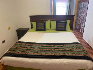 a bedroom with a large bed with green pillows at Casa Solcoy in San Pedro de Atacama