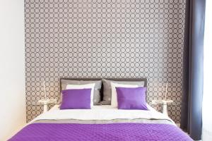 a bedroom with a purple bed with purple pillows at Tesla Boutique Apartments & Rooms in Zagreb