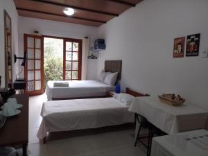 una camera da letto con due letti e una finestra di Loft da Montanha (A 8min do centro) a Nova Friburgo