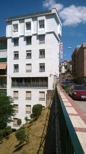 een wit gebouw met ramen aan de straatkant bij Hostal Blazquez Sanchez in Béjar