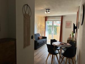 ein Wohnzimmer mit Tisch und Couch in der Unterkunft L'Étape Cosy, Parking Gratuit in Carcassonne + 18 Fotos