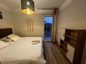 ein Schlafzimmer mit einem Bett und einem Kronleuchter in der Unterkunft L'Étape Cosy, Parking Gratuit in Carcassonne