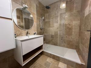 ein Badezimmer mit Badewanne, Waschbecken und Spiegel in der Unterkunft L'Étape Cosy, Parking Gratuit in Carcassonne