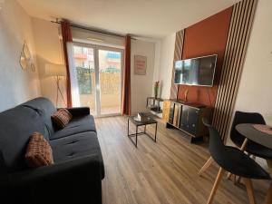 ein Wohnzimmer mit Sofa und Tisch in der Unterkunft L'Étape Cosy, Parking Gratuit in Carcassonne