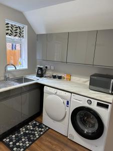 a kitchen with a washing machine and a sink at The Cosy Place near centre in Ipswich