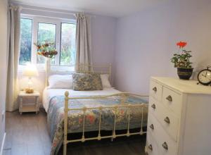 a bedroom with a bed with a dresser and a window at Elmbank Garden Apartment in Oban