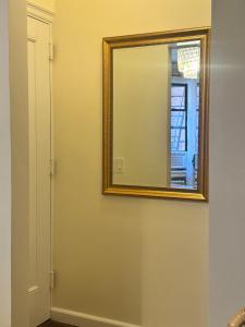 a mirror on a wall next to a door at West Village Lush Green in New York