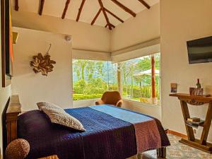 een slaapkamer met een bed en een groot raam bij Finca del Café - Casa Typica in Santa Rosa de Cabal +66 foto's