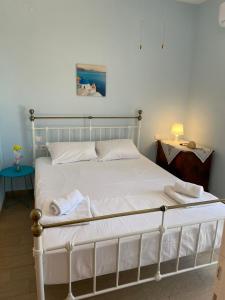 a bed with white sheets and towels on it at Theros house in Kythira