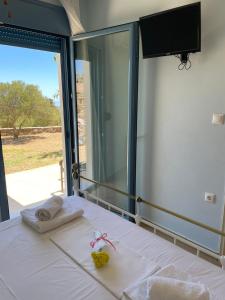 a room with a bed with a large window at Theros house in Kythira