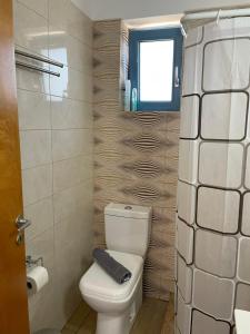 a small bathroom with a toilet and a window at Theros house in Kythira