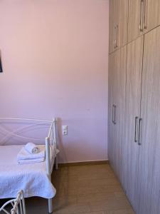 a white room with a bed and a cabinet at Theros house in Kythira