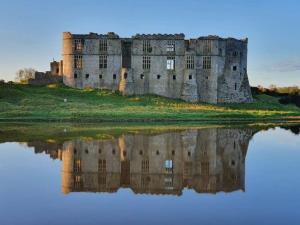 a castle with its reflection in the water at Cherry Blossom in Pembrokeshire