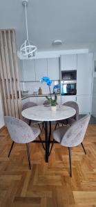 una mesa y sillas con un jarrón de flores. en Plava orhideja apartman, en Trebinje