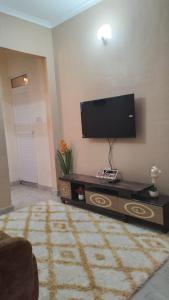 a living room with a flat screen tv on the wall at CoolHome at Mbezi Beach in Dar es Salaam