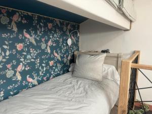 a bedroom with a bed with a floral wallpaper at ÔTroisChênes - Gîte au calme avec spa privatif in Saint-Astier