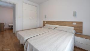 a bedroom with a large bed with a wooden headboard at Apartamentos Borriana in Burriana