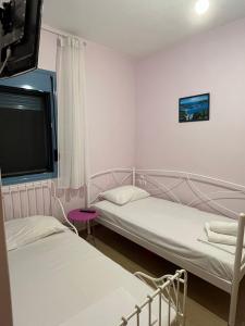 two beds in a small room with a tv at Theros house in Kythira