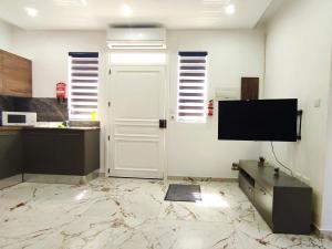 a kitchen with a tv and a white door at Charming Studio in Historic Kalkara Malta in Kalkara +8 photos