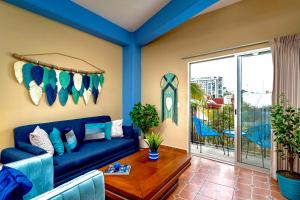 a living room with a blue couch and a table at Just Beachy PV in Puerto Vallarta