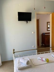 a bedroom with a bed with a flat screen tv on the wall at Theros house in Kythira