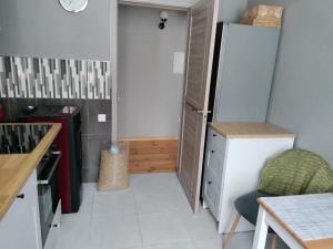 a kitchen with a refrigerator and a chair in it at Located in Ances pagasts Apartments in Ance