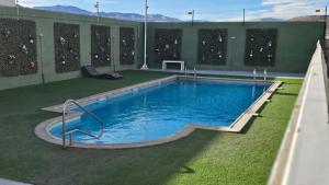 a large swimming pool on a building with grass at comodidad-seguridad-conectividad in Calama