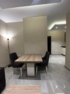 a dining room with a wooden table and chairs at Chic Apartments For Rent ave2-4 in Amman +5 photos