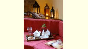 a table with a red table cloth and a tray with tea sets at Adrasteia Guesthouse in Negádes