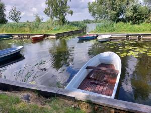 Ein Boot liegt im Wasser neben anderen Booten. in der Unterkunft Kleine Jagdhütte in Zettemin