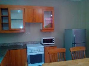 y cocina con fogones azules y nevera. en Pacific Villa Home, en Lapu Lapu City