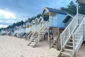 a row of beach huts on a sandy beach at The Top Deck, Wells-next-the-Sea in Wells next the Sea
