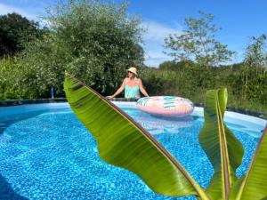 a woman in a hat sitting in a pool with alatable raft at Weberhof - Münster 6 in Münster