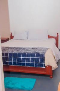 une chambre avec un lit avec un matelas bleu et blanc dans l'établissement Eco Cottage BnB, à Ruhengeri