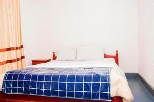 - un lit avec une couverture bleue et blanche dans l'établissement Eco Cottage BnB, à Ruhengeri 2 autres photos