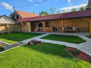 a house with a patio with a table and chairs at Vila Banstolija in Velika Remeta