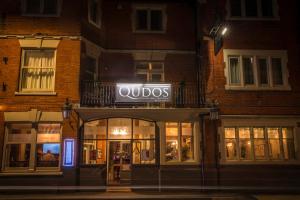 a store with a lit up sign in front of a building at Qudos in Salisbury