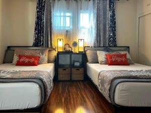 1 dormitorio con 2 camas con almohadas rojas y ventana en GSH202-Green Sweet Home-Disneyland and Little Saigon, en Westminster