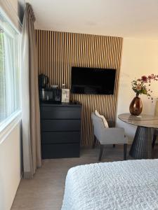 a bedroom with a bed and a table and a television at Chalet Parfait in Bergen