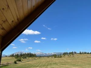 a view from a barn window of a field and mountains at Eternum Glamping in Žabljak