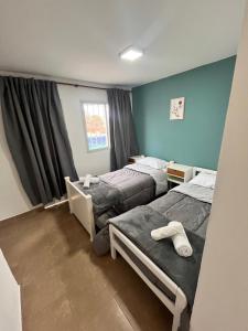 two twin beds in a room with blue walls at Hospedaje LH primero D in La Unión