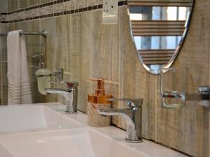 lavabo con 2 grifos y espejo en Thornville Guest house Platinum, en Pietermaritzburg