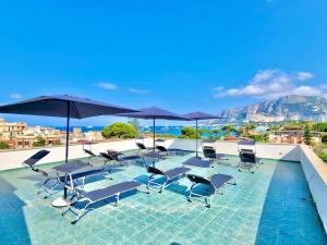 a group of chairs and umbrellas on a swimming pool at Mongibello Rooftop in Mondello