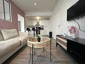 a living room with a couch and a table at Appartement Centre-ville 200m gare Vernon - proche Giverny in Vernon