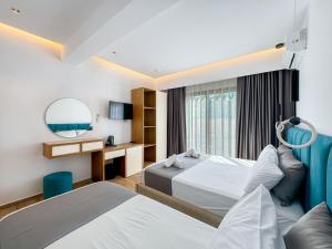 a hotel room with two beds and a mirror at Zace Studios in Ksamil