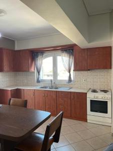 a kitchen with wooden cabinets and a table and a stove at Peter appartments in Vrachati