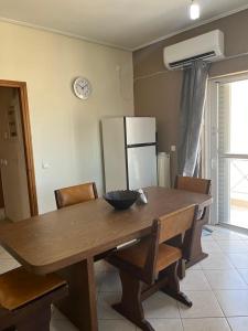 a kitchen with a wooden table with chairs and a refrigerator at Peter appartments in Vrachati +6 photos